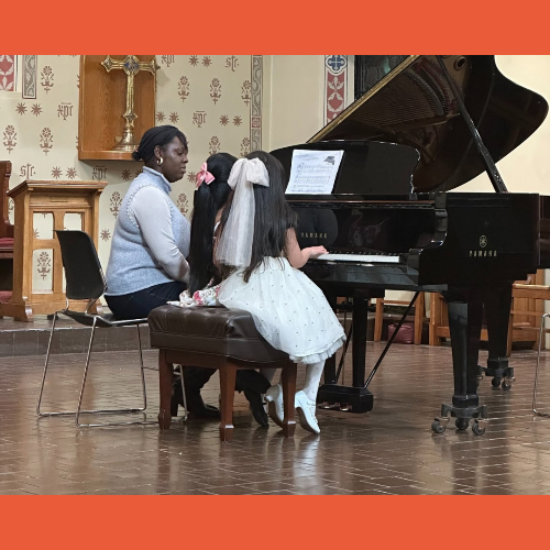 Music teacher and two girl play piano