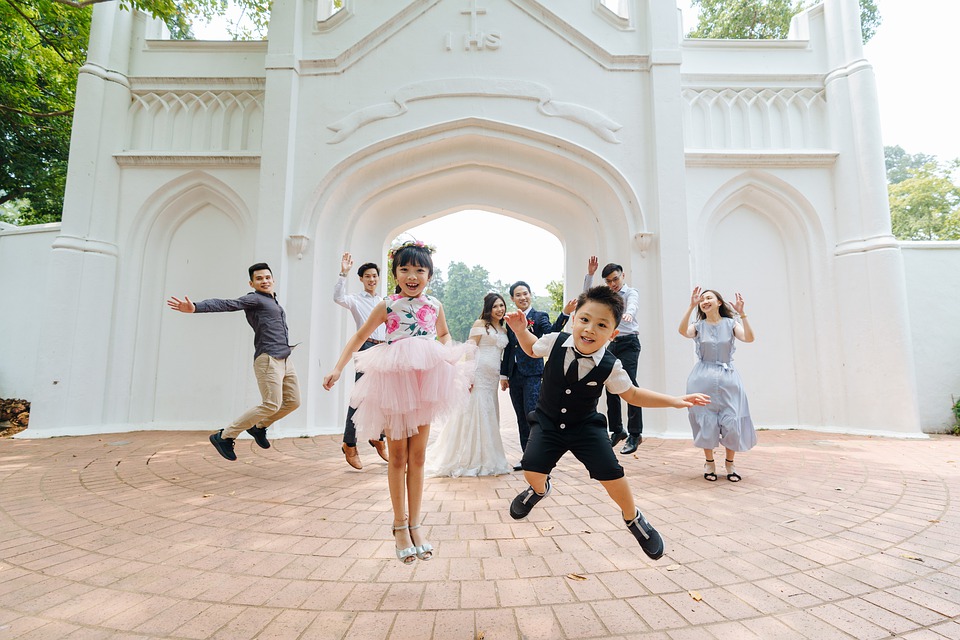 Kids jumping in front of a wedding party