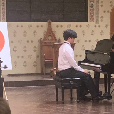 Young boy playing piano at recital