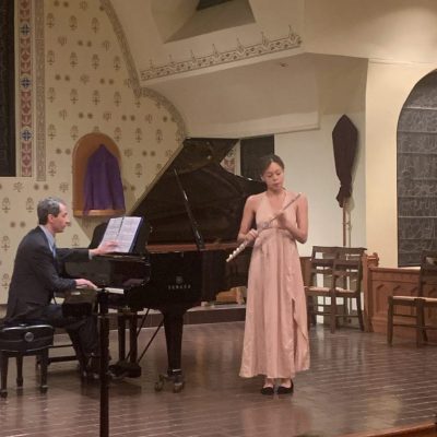 Flutist and pianist performing on stage