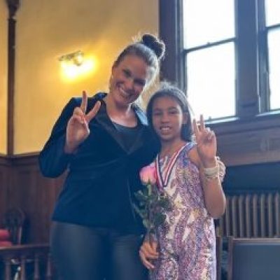 Woman and young girl holding up peace signs